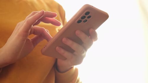 Person Scrolling on Mobile Phone Indoors