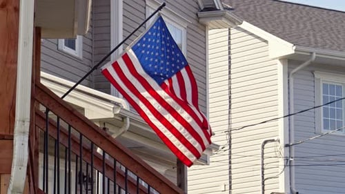American flag waving next to home on stairs