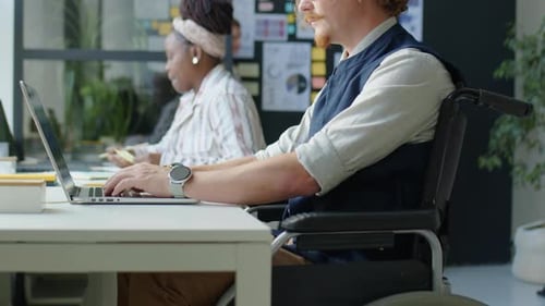 Office Worker in Wheelchair Using Laptop