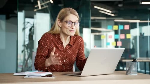 Woman Celebrates Success at Computer in Office