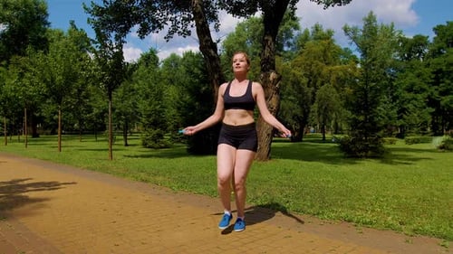 Lovely Active Sporty Fit Woman Doing Jump Rope Cardio Workout in Park