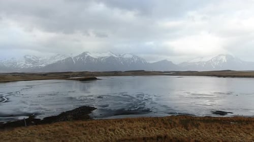 Beautful Icelandic landscape with Mountain View with a silvery reflecting lake a and cloudy sky