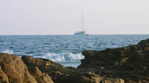 Sailboat Cruises on Open Sea White Yacht Sails Near Rocky Coast Leisure Ocean Voyage Adventure