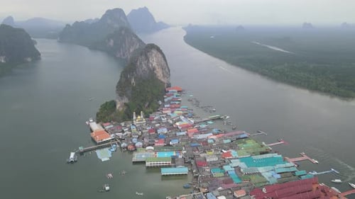 Voe de volta para a vista aérea da vila de shows da ilha de Panyee e um barco navegue no mar com céu nublado.