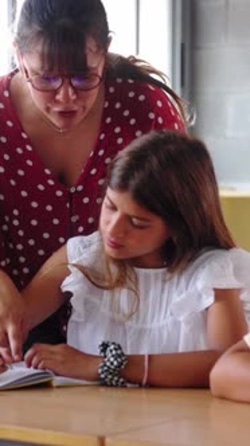 Girl Studying in School Classroom with Teacher