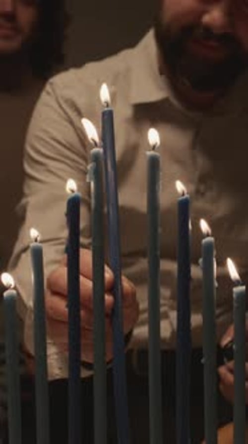 Un hombre en kipá enciende todas las velas en el último día de Janucá