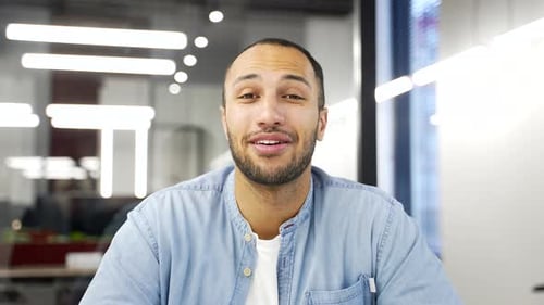 Webcam view. African american businessman talking on a video call looking at camera sitting at desk