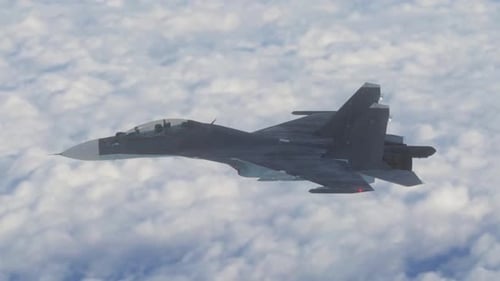 Military Fighter Jet Flying Above White Clouds