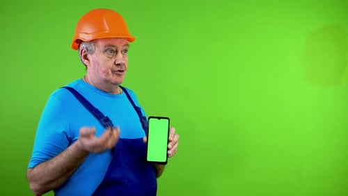 Man in Hardhat Holds Green Screen Smartphone