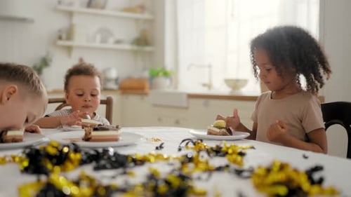 Children Birthday Party Multiracial Kids Sitting at Table and Tasting Cake Happy Black and Caucasian