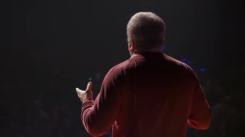 Man Speaker at Business Conference Stage Talking to People Sitting in Auditorium