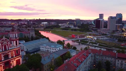 Aerial pink sunset view of Vilnius, Lithuania with reflections on river