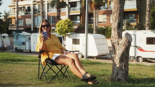 Woman Using Mobile Phone Relaxing Outdoors