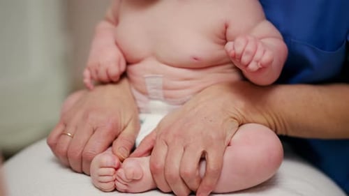 Adult Massaging Baby Feet in Hospital, Close Up
