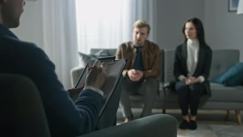Couple in Therapy Session with Therapist Taking Notes