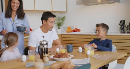 Family enjoying breakfast together in modern kitchen