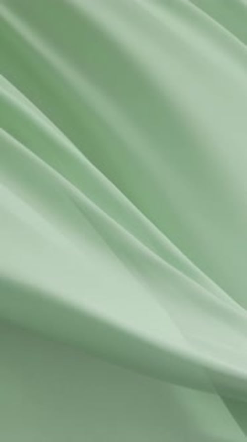 Soft Bright Green Fabric Flowing Gracefully in Air Creating Elegant Minimal Texture Background with
