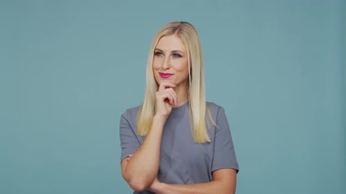 Young Beautiful Blond Girl in the Studio Portrait of Emotional Girl on Blue Background