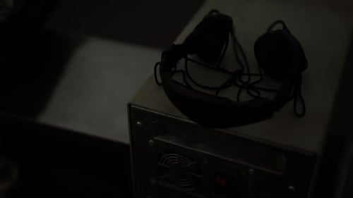 Headset Placed on a Metallic Surface in a Dimly Lit Room