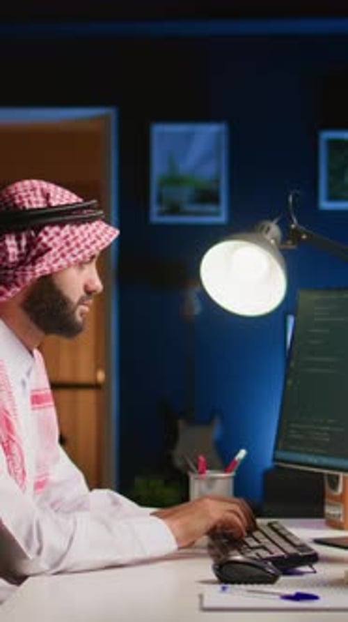 Young Adult Working on Computer in Office at Night
