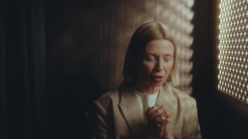 Woman Clasping Hands in Prayer and Reflection