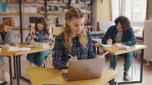 Students Study Together Using Laptop in Bright Library