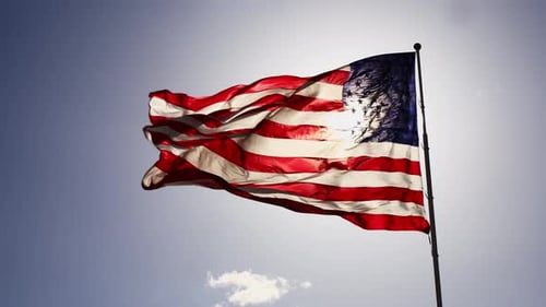 American Flag Waving Proudly Against Blue Sky