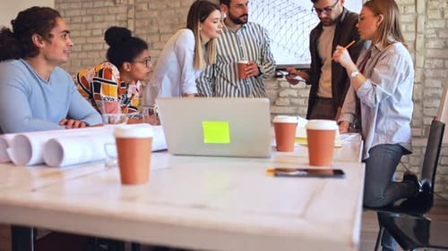 Group of young business people discussing architectural designs in office.