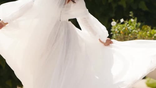 Bride Twirling in Wedding Dress in Garden