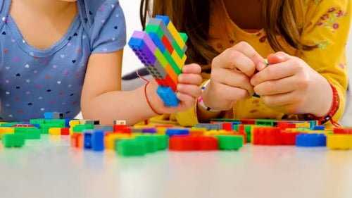 Children Playing with Colorful Building Blocks at Home