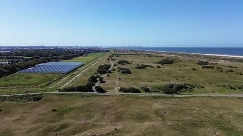 Top view of the beach kijkduin and sea. Flight over fields with green grass and buildings on the sea
