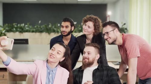 Young handsome businesspeople taking selfie on phone in office at work