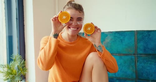 Smiling Woman Posing with Oranges and Eye Patches