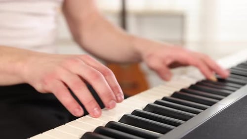 Man playing synthesizer at home, closeup. Musical instrument