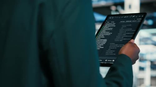 Close Up of Data Center Programmer Using Tablet App to Write Code