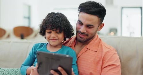 Father and Son Enjoying Tablet Together Indoors