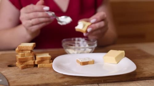 Woman Spreads Cheese on Toast for a Snack
