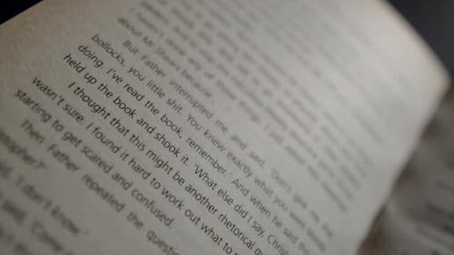 Close up over an open book page with out of focus words