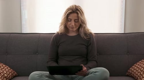 Woman Using Tablet on Couch at Home