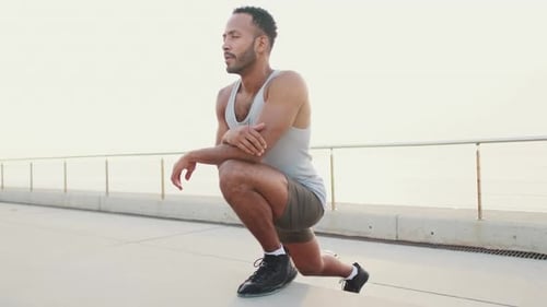 Young fit athletes stretches on the embankment