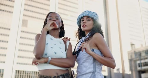 Two Stylish Women Posing in City Scene