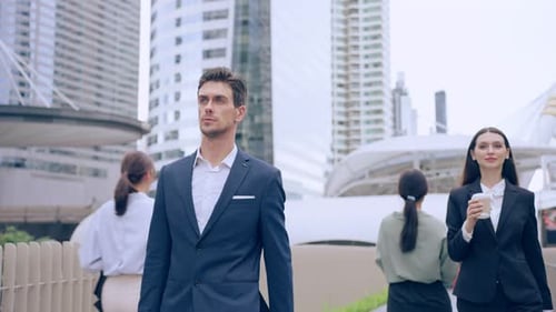 Caucasian businessman and businesswoman walking outdoors in the city.