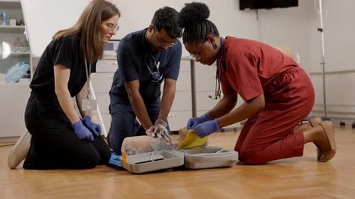 Medical students practicing chest compressions and resuscitation on a dummy