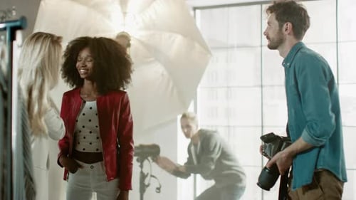 Entre bastidores de la sesión de fotos: el maquillador aplica maquillaje a una hermosa modelo negra, en un momento P