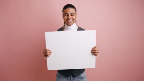 Smiling Young Man Holding a Blank White Sign for Advertising
