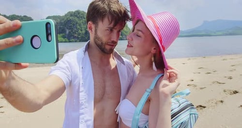 Carefree couple capturing Thailand beach vacation memories with smartphone on phi phi island