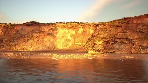 Textured Rugged Cliff in Amber Tones with Flowing Water Foreground