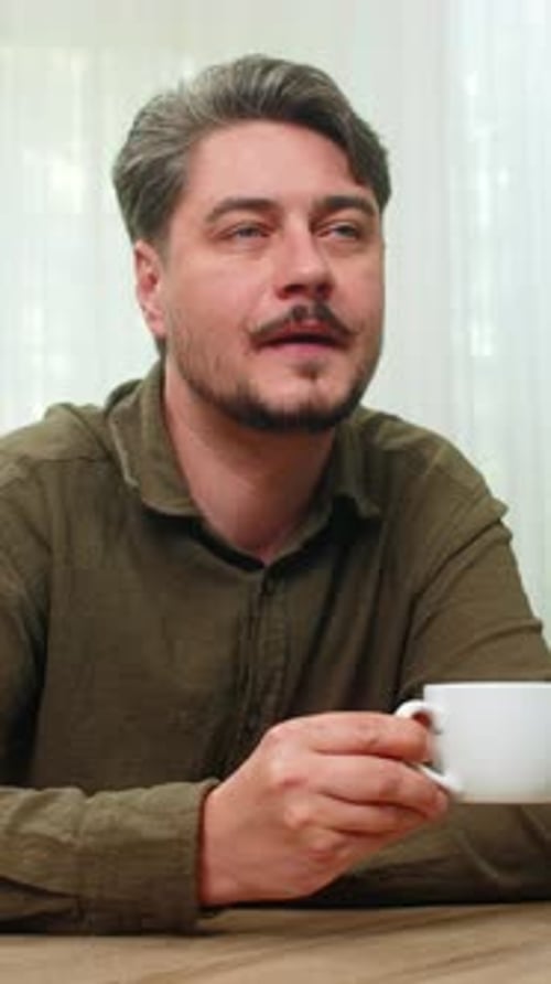 Man Drinking Coffee at Table Portrait