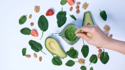 Healthy Vegan Green Spinach Smoothie Spinach and Avocado on a White Background Top View Close Up of