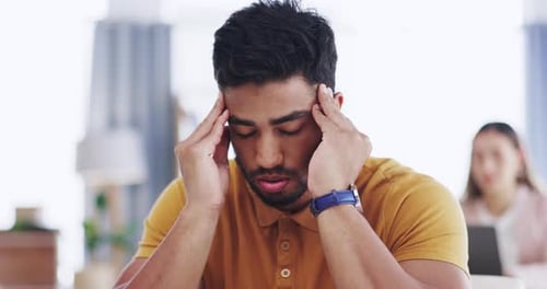 Man Massages Temples in Home Office